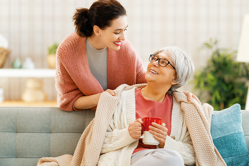 beautiful-mother-daughter-talking-smiling-while-sitting-couch